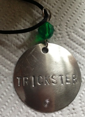 Trickster hand stamped on silver with acrylic faceted bead on black satin cord